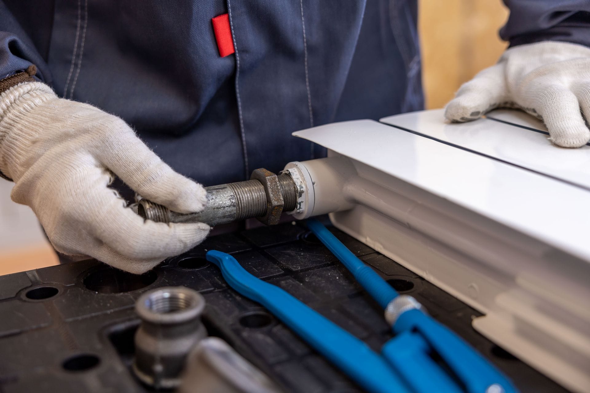 Plumber repairing a boiler in a home in Exampleton