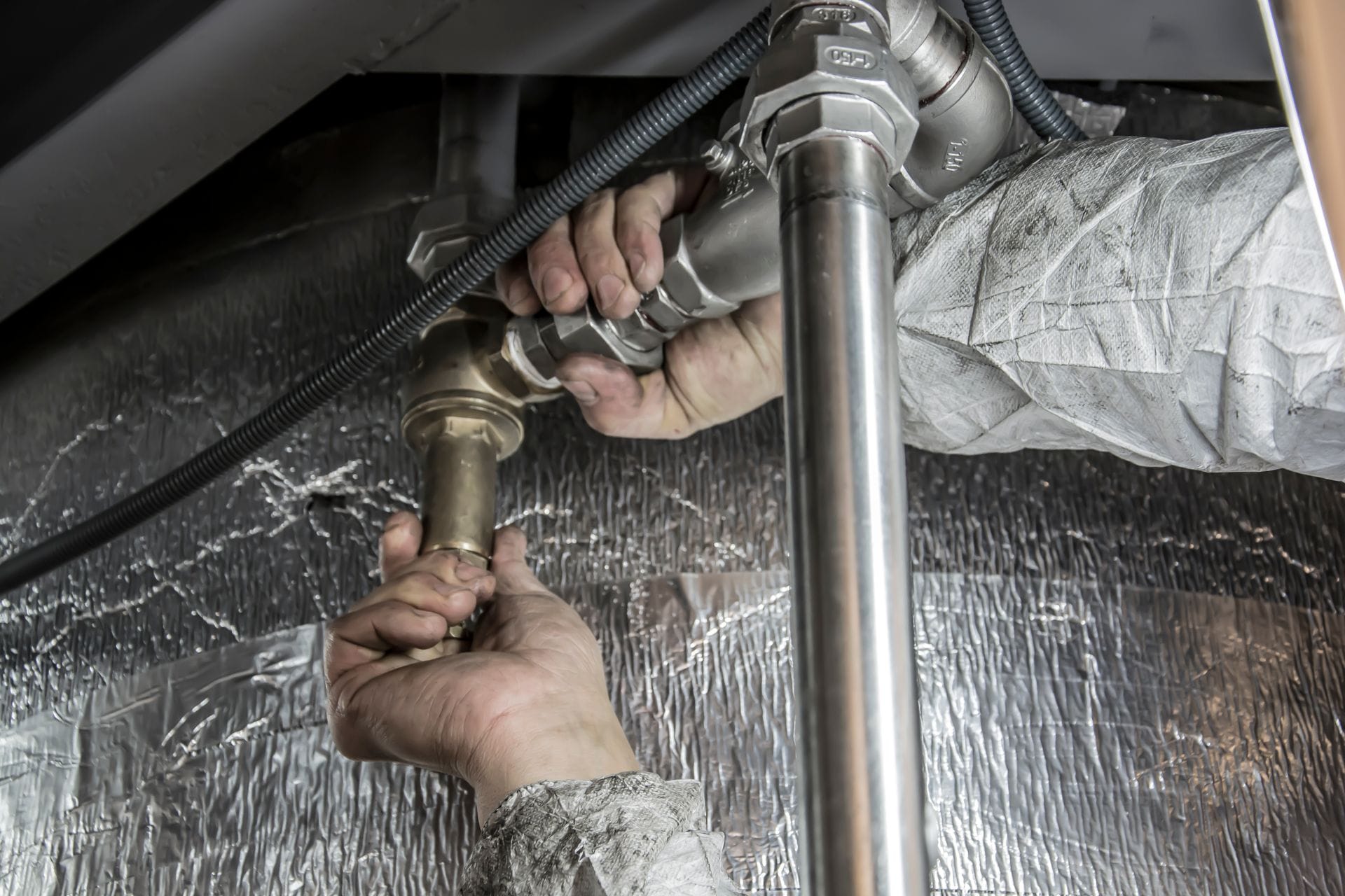 Professional plumber fixing pipes